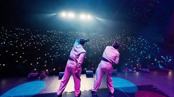 The French Twins performing on a major televised magic stage in front of a large audience.