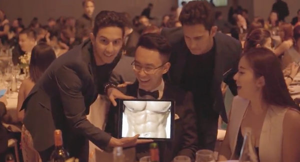 The French Twins performing a close up iPad routine for a seated guest at a corporate dinner.