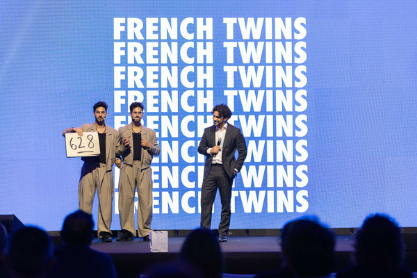 The French Twins performing a mentalism number with a number prediction on stage.