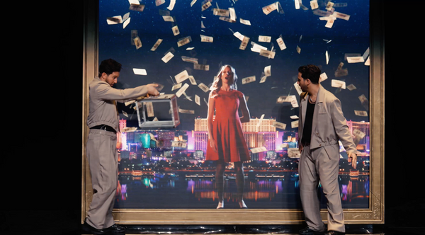 The French Twins performing a Las Vegas themed routine with money raining and a woman in a red dress on the LED screen.
