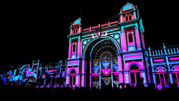 Video mapping projection on a historic building facade at night.